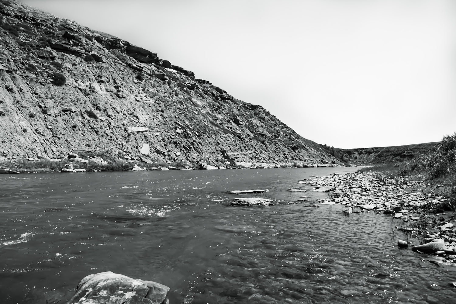 Black and white image of the Two Medicine River with its rocky breaks